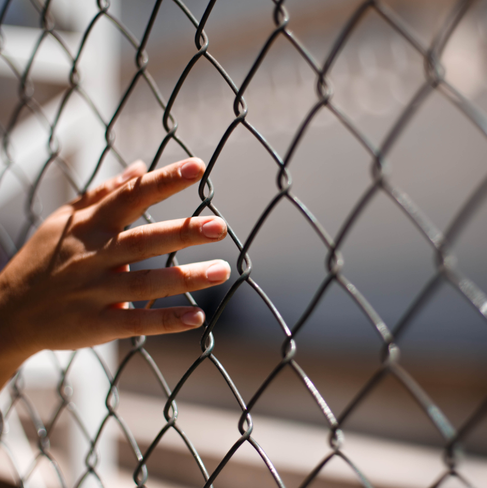 hand on a chainlink fence